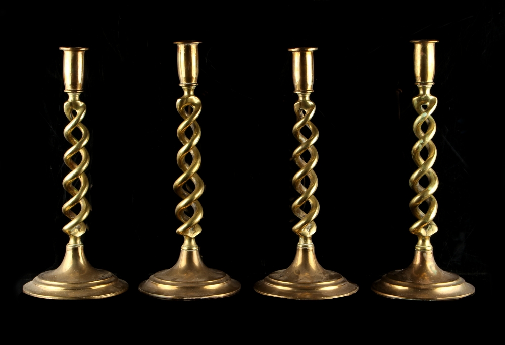 Property of a gentleman - a set of four early 20th century brass hollow barleytwist candlesticks,