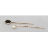 Property of a lady - a stickpin with glazed oval panel bordered by seed pearls; together with