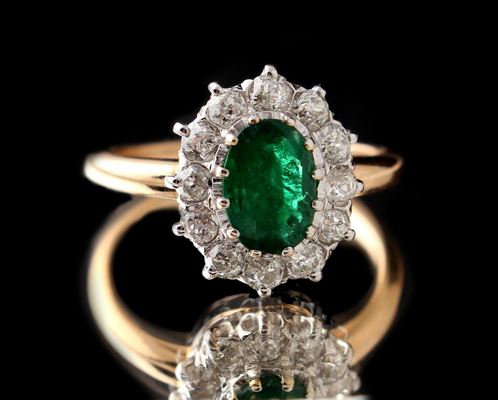 An unmarked yellow gold emerald & diamond cluster ring, the oval cut emerald approximately 0.80 - Image 2 of 2