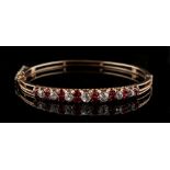 A Victorian yellow gold spinel & diamond hinged bangle, circa 1870, set with alternating pairs of