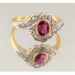 A late 19th / early 20th century 18ct yellow gold ruby & diamond ring, of oval crossover form, the