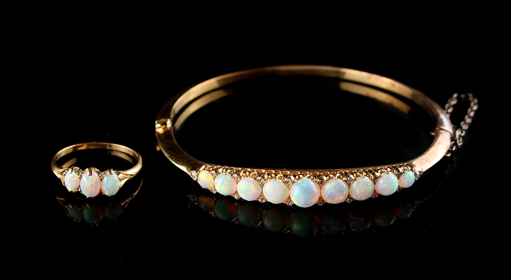 Property of a lady - an Edwardian 18ct yellow gold opal & diamond hinged bangle, the nine