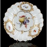 Property of a lady - an early 20th century Meissen shallow dish, with moulded gilt panels, painted