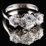 A very good diamond three stone ring, the centre round brilliant cut diamond weighing