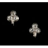 A pair of diamond three leaf clover shaped earrings, for pierced ears, with rub over settings, the