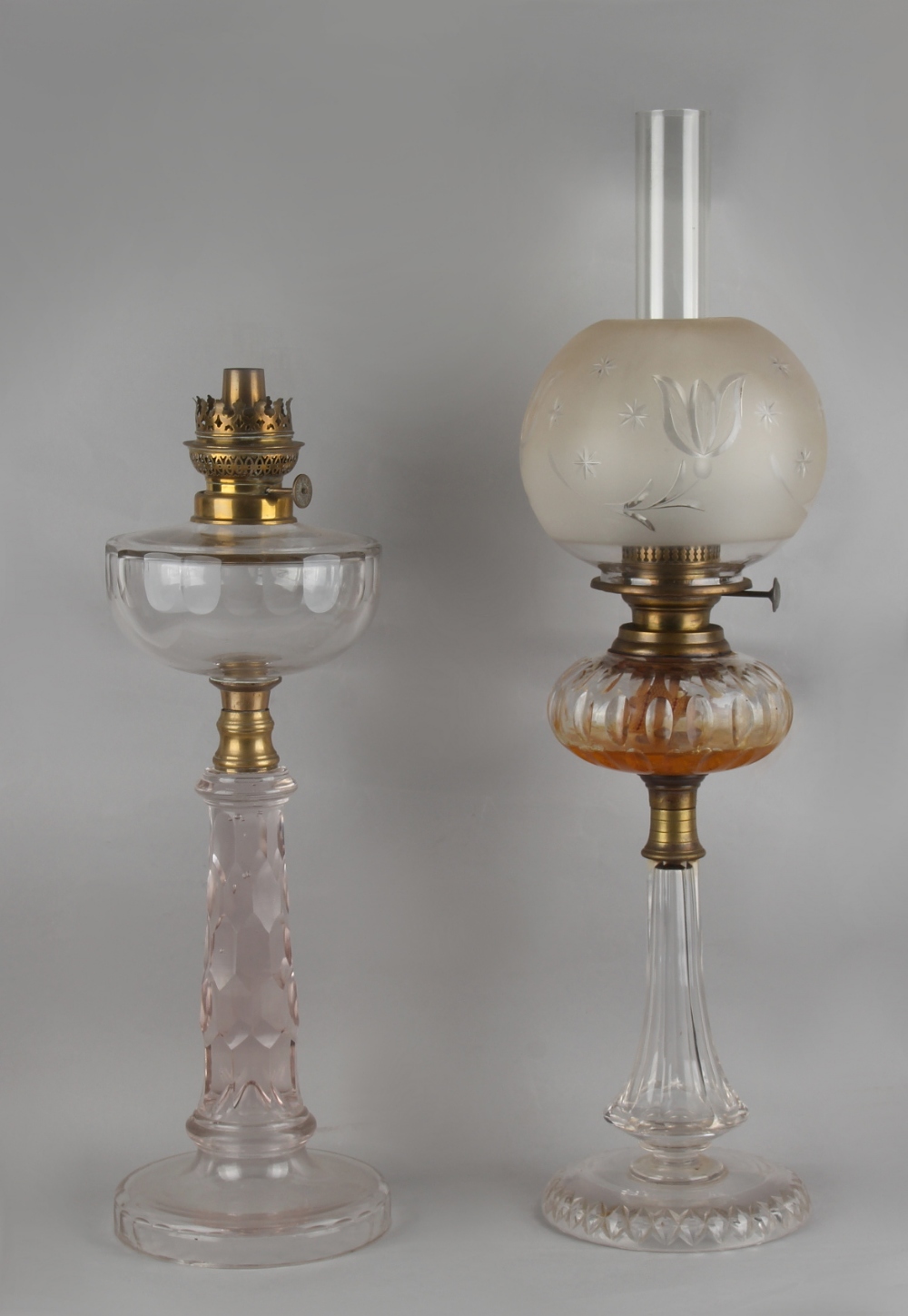 Two early 20th century cut glass paraffin oil lamps, the taller 25.6ins. (65cms.) high (overall) (2)