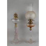 Two early 20th century cut glass paraffin oil lamps, the taller 25.6ins. (65cms.) high (overall) (2)