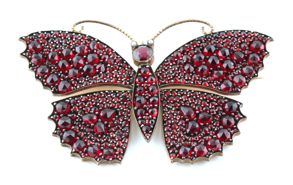 A large garnet butterfly brooch, with rose cut garnets & seed pearl eyes, 78mm across, approximately