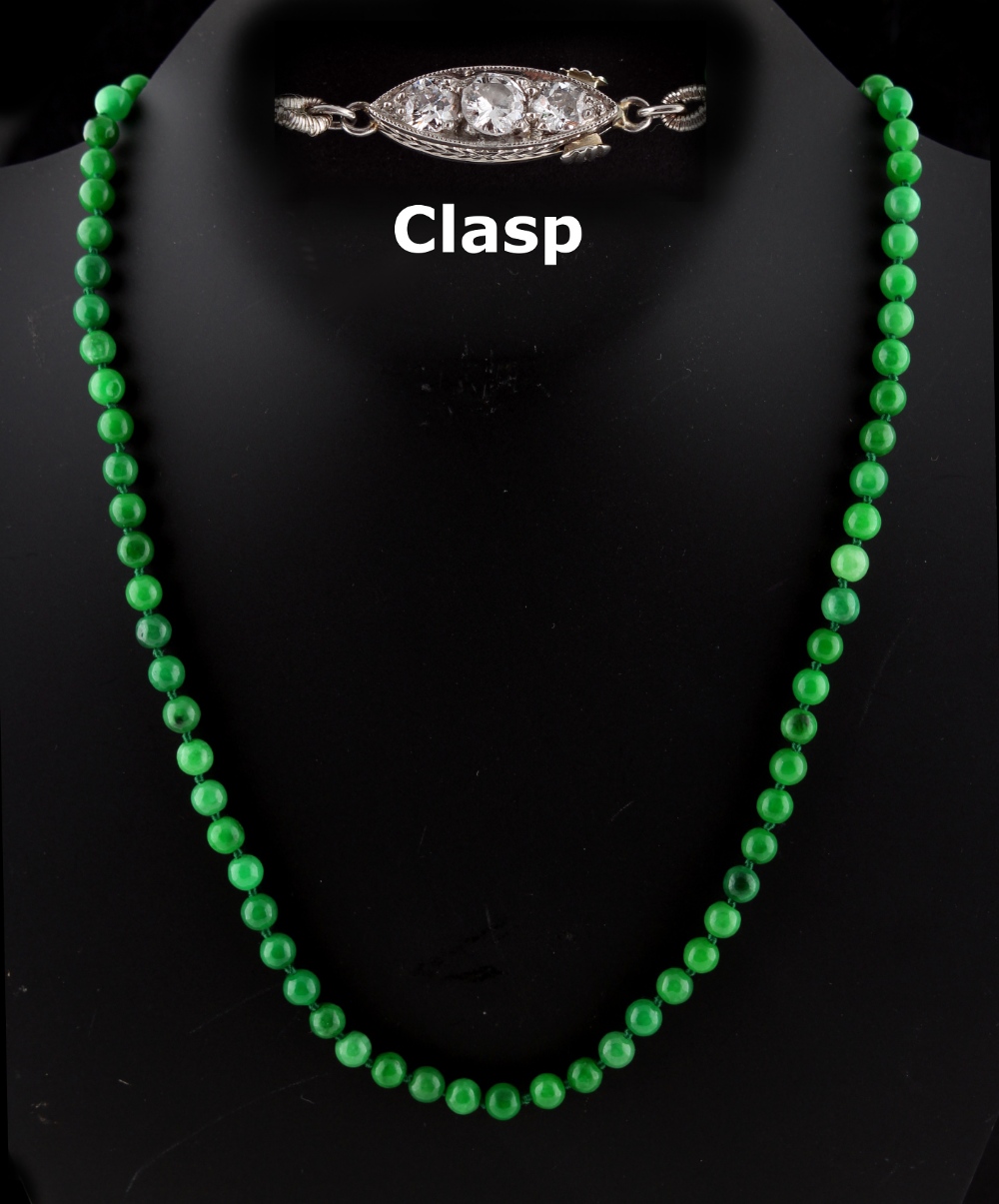 A Chinese apple green jadeite bead necklace, the seventy-five individually strung uniform beads each