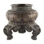 A late 19th / early 20th century bronze tripod censer, with a raised band of stiff leaves, on