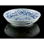 A Chinese blue & white dragon dish, the base un-glazed, 8.1ins. (20.5cms.) diameter (see