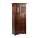 A reproduction carved oak hall cupboard, with linenfold panels, 32.5ins. (82.5cms.) wide (
