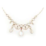 An unmarked yellow gold moonstone & ruby festoon necklace, 16ins. (40.5cms.) long (see