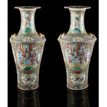 A large pair of 19th century Chinese famille rose vases, each painted with panels of figures in