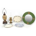 A green painted circular framed wall mirror; together with two table lamps; and three meat-plates (