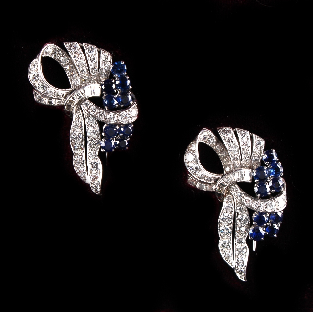 A good pair of unmarked white gold sapphire & diamond tied ribbon clips, each set with nine round