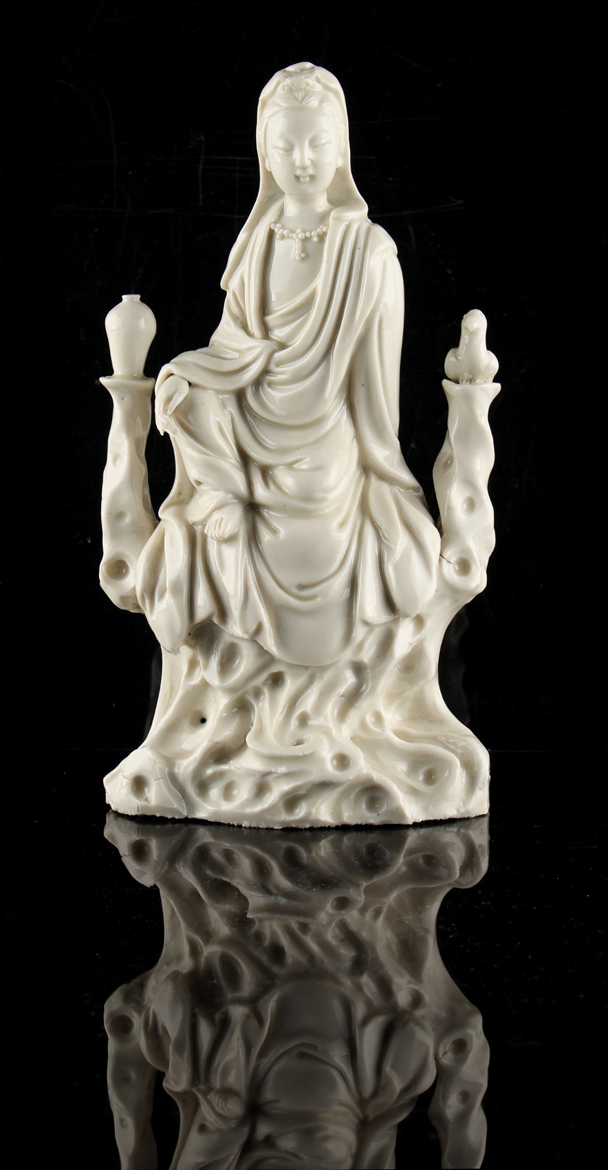 A Chinese Dehua blanc de Chine figure of Guanyin, modelled seated, 7.9ins. (20cms.) high (see