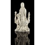 A Chinese Dehua blanc de Chine figure of Guanyin, modelled seated, 7.9ins. (20cms.) high (see