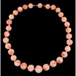 A Chinese carved coral graduated bead necklace, the largest bead approximately 18.5mm diameter,