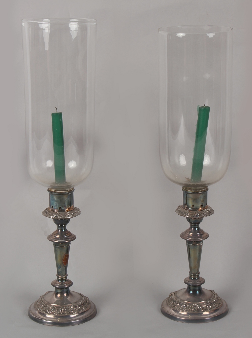 Property of a deceased estate - a pair of silver plated candlesticks with glass storm shades, each