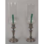 Property of a deceased estate - a pair of silver plated candlesticks with glass storm shades, each