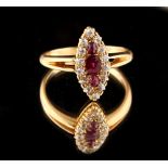 An unmarked high carat yellow gold ruby & diamond ring, with navette shaped setting & bifurcated