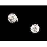 A pair of 18ct white gold diamond solitaire stud earrings, with butterfly fastenings, the