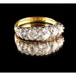 An unmarked high carat yellow gold diamond graduated five stone ring, with scroll setting, the