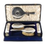 Property of a lady - a cased silver backed mirror & brush set, Birmingham 1913/14.