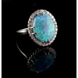 Property of a lady - an Australian black opal & diamond oval cluster ring, the opal approximately