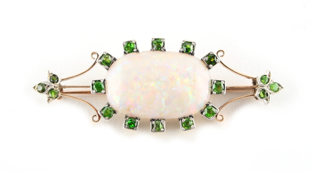 An opal & demantoid garnet brooch, the oval opal measuring approximately 23 by 15mm, approximately