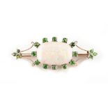 An opal & demantoid garnet brooch, the oval opal measuring approximately 23 by 15mm, approximately