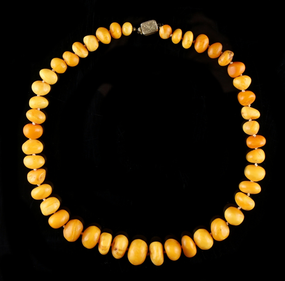 Property of a deceased estate - a butterscotch amber graduated pebble bead necklace, the largest