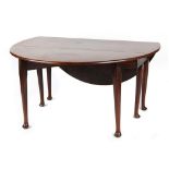 An 18th century George III Irish mahogany oval topped drop-leaf dining table with six club legs