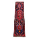 A Hamadan woollen hand-made runner with red ground, 110 by 28ins. (280 by 70cms.).