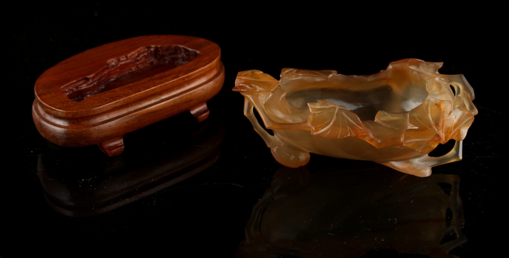 A Chinese agate leaf brush washer, 3.7ins. (9.4cms.) long, with later associated hardwood stand. - Image 2 of 2
