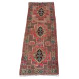 An Esari woollen hand-made carpet with beige ground, 115 by 44ins. (290 by 110cms.).