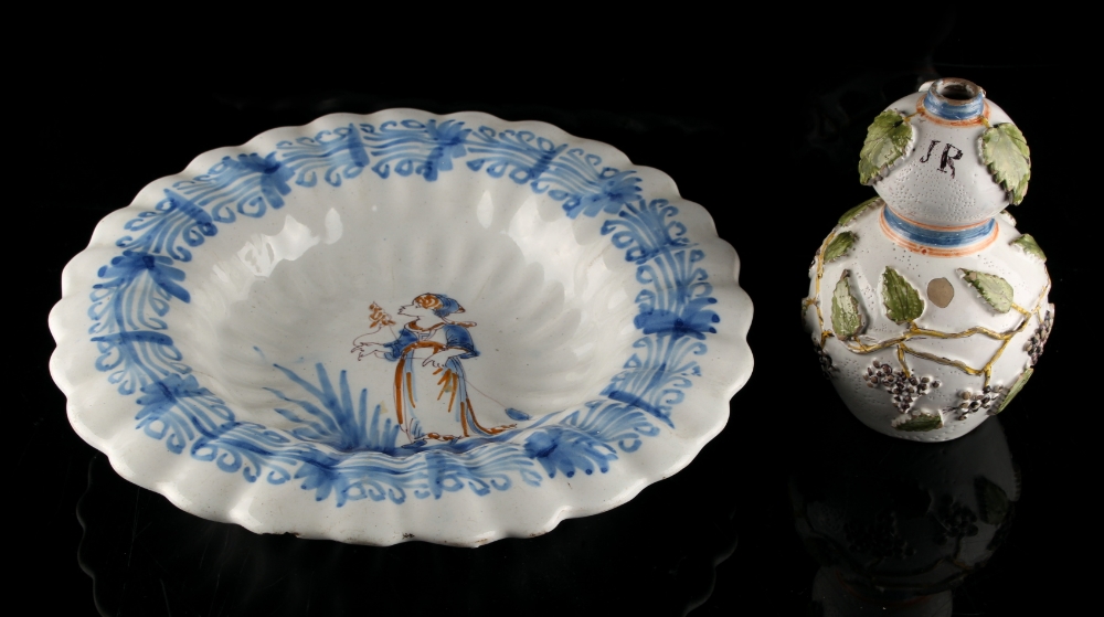 A French faience fluted dish, 18th century, painted with a maiden holding a flower, 12.2ins. (