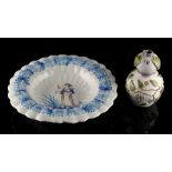 A French faience fluted dish, 18th century, painted with a maiden holding a flower, 12.2ins. (