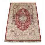 A Kashan style rug with red ground, 79 by 55ins. (200 by 140cms.).