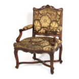 A late 19th century French Louis XIV style carved fruitwood open armchair, with cabriole legs &