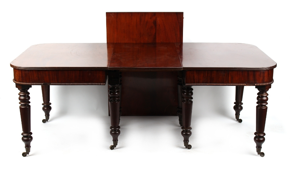 An early 19th century mahogany telescopic extending dining table, with two extra leaves, on turned