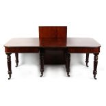 An early 19th century mahogany telescopic extending dining table, with two extra leaves, on turned