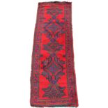 Property of a deceased estate - a Turkish runner, with red ground, 100 by 35ins. (254 by 90cms.).