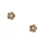 A pair of unmarked yellow gold emerald & seed pearl flowerhead earrings, each with a central seed