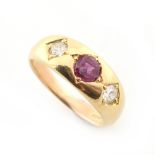 A 14ct yellow gold ruby & diamond three stone gipsy set ring, the octagonal cut ruby approximately