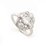 An Art Deco style platinum & diamond ring, the central emerald cut diamond flanked by baguette cut