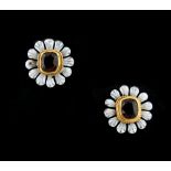 A pair of cut garnet & white enamel flowerhead earrings, with post & butterfly fastenings, each