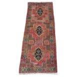 An Esari woollen hand-made carpet with beige ground, 115 by 44ins. (290 by 110cms.).