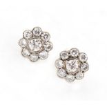 A pair of diamond cluster earrings, each set with nine round brilliant cut diamonds, the estimated